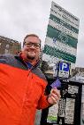 Photo of Councillor Damien Greenhalgh with one of the ticket machines that are set to be replaced